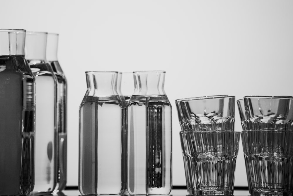 ein Tisch mit Gläsern und Vasen, die mit Flüssigkeit gefüllt sind