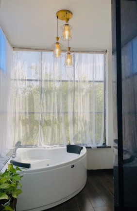 a bathroom with a round tub and a window