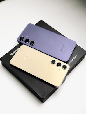 three different colors of cell phones sitting on top of each other