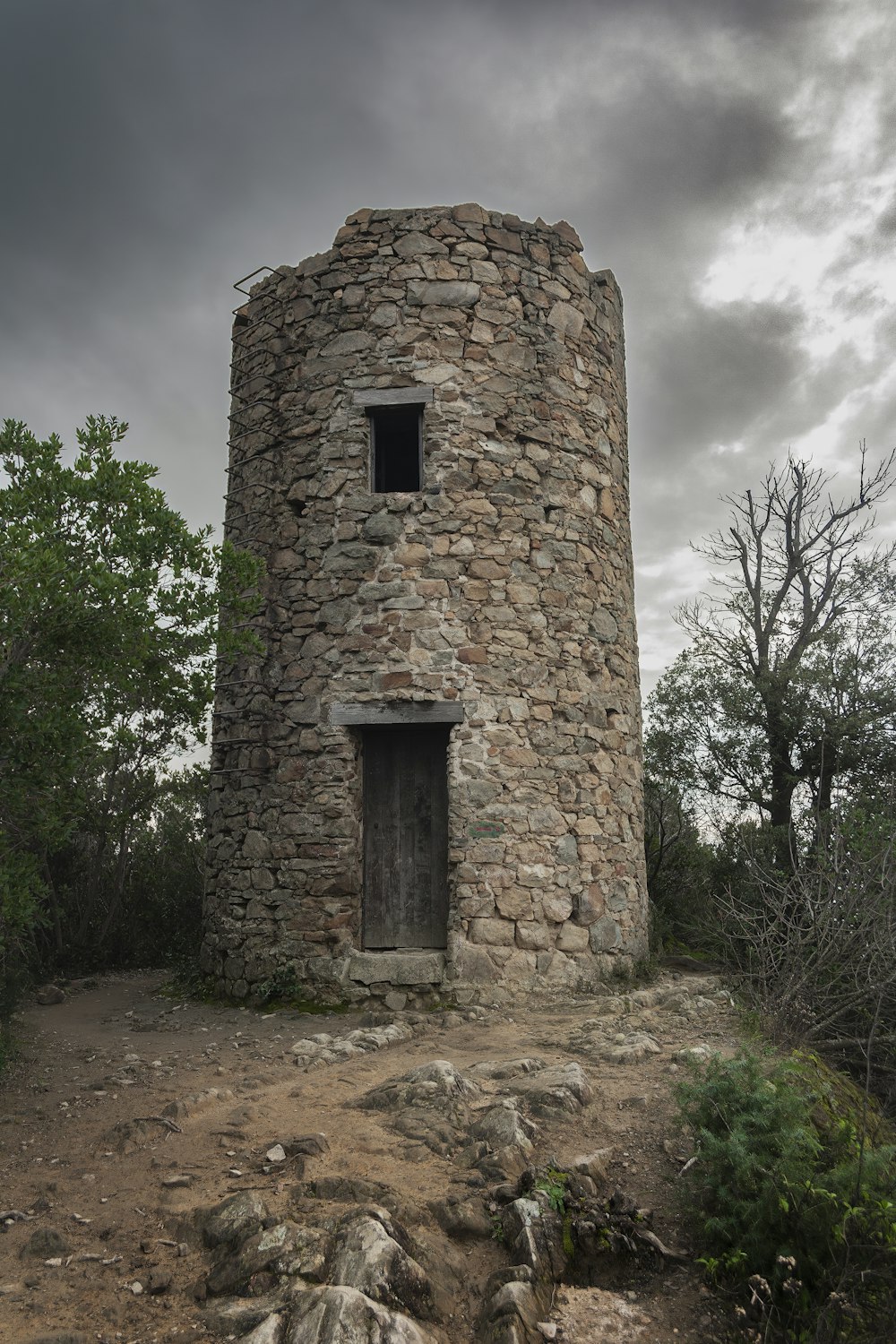 a stone tower sitting on top of a dirt hill