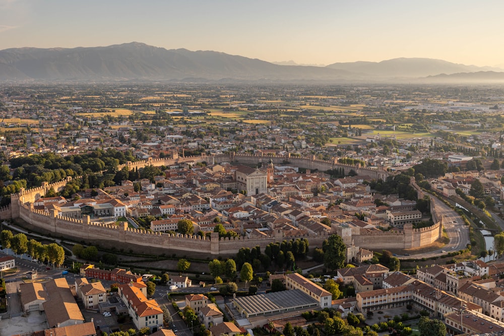 an aerial view of a city with mountains in the background