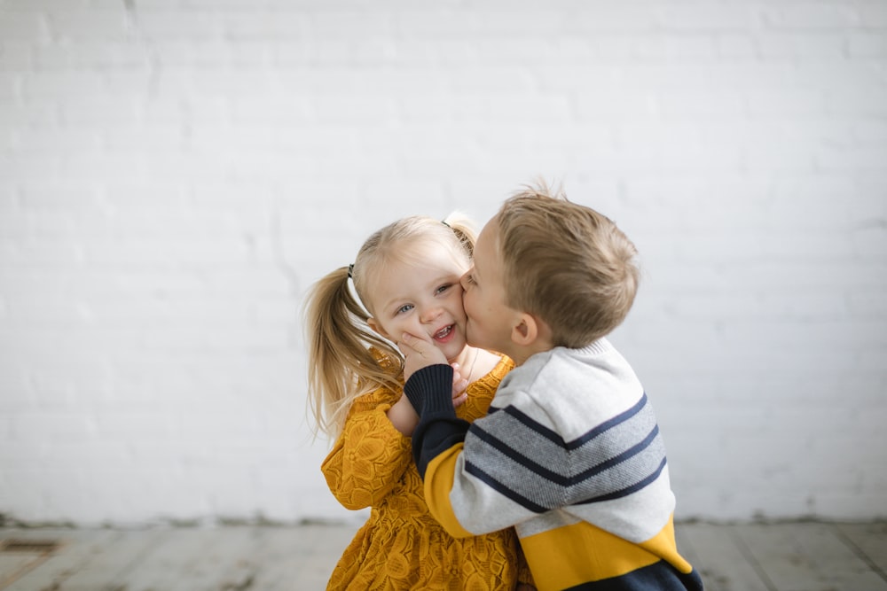 a little girl and a little boy hugging each other