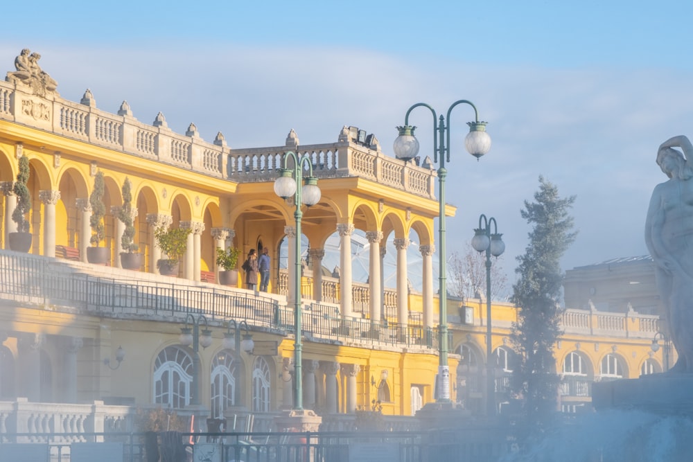 a yellow building with a fountain in front of it