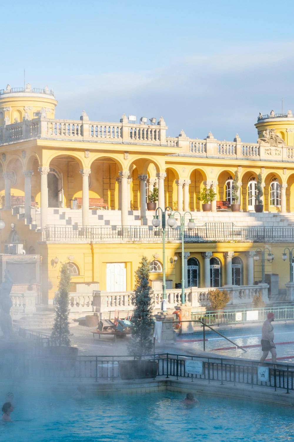 a large yellow building with a fountain in front of it