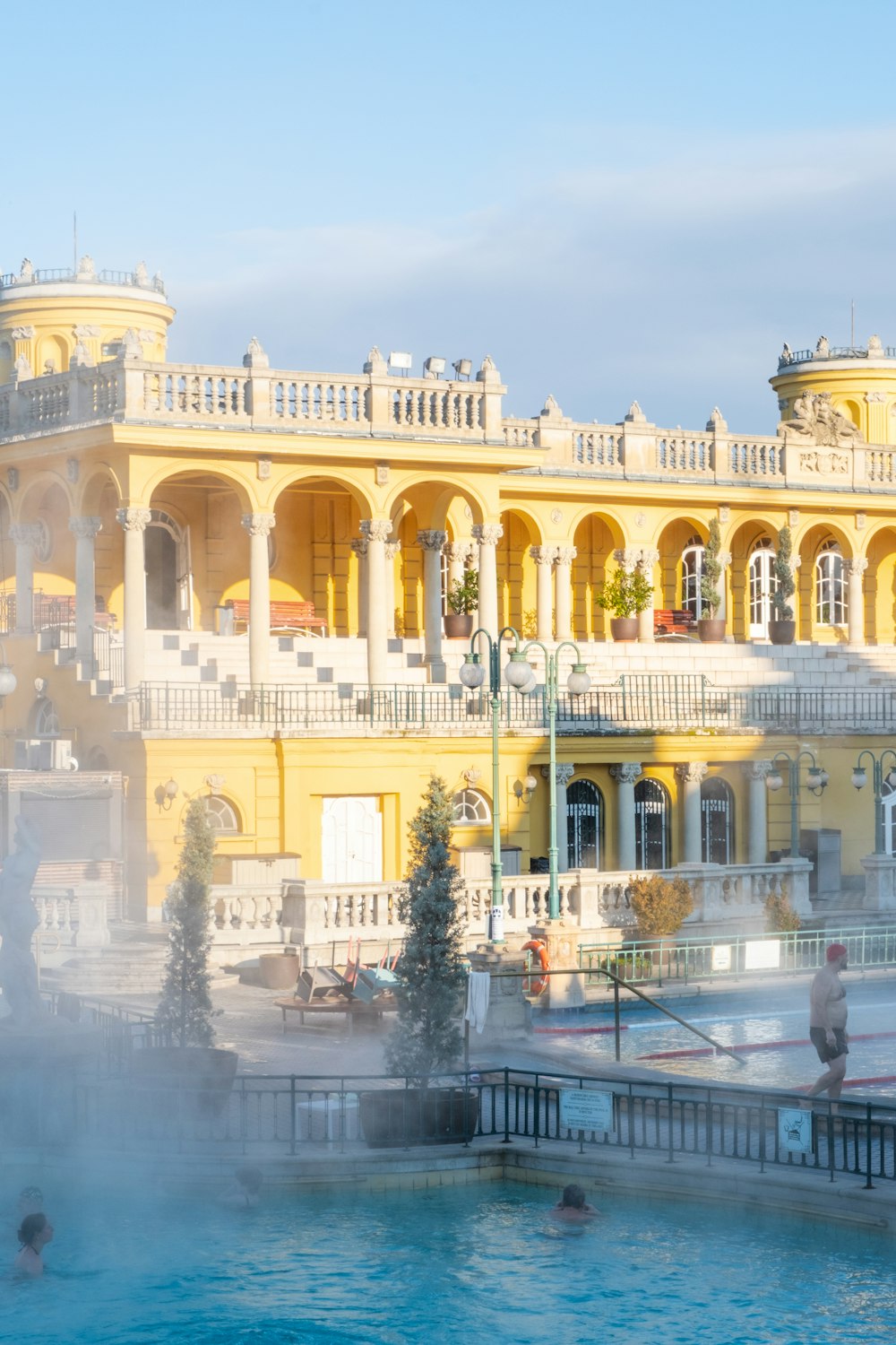 a large yellow building with a fountain in front of it