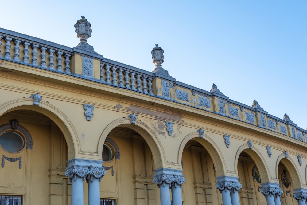 a yellow building with blue columns and arches