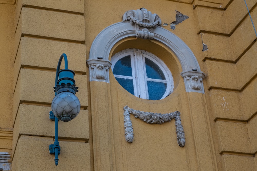 a yellow building with a window and a clock on it