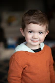 a little boy that is smiling for the camera