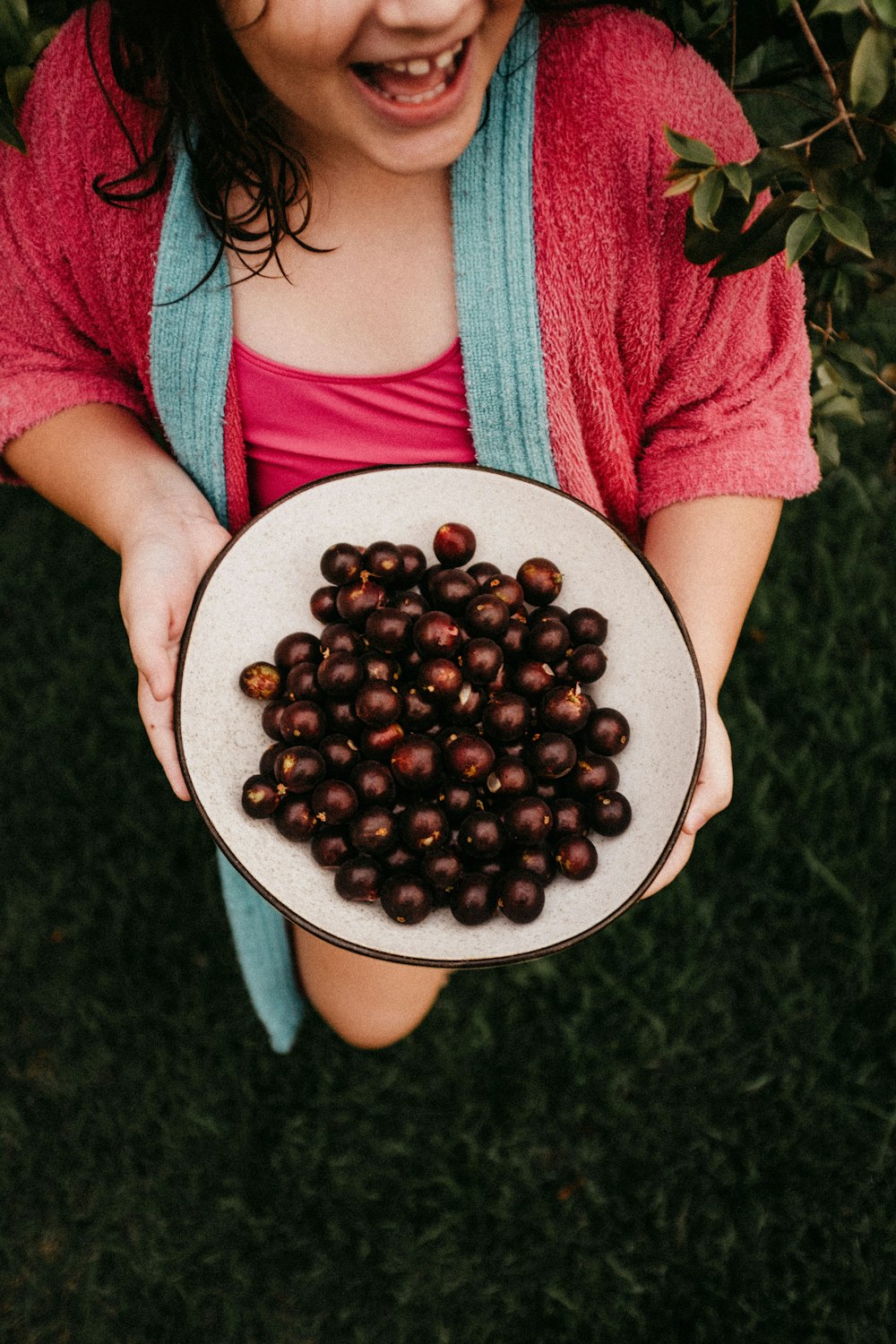 a girl holding a plate of chestnuts in her hands
