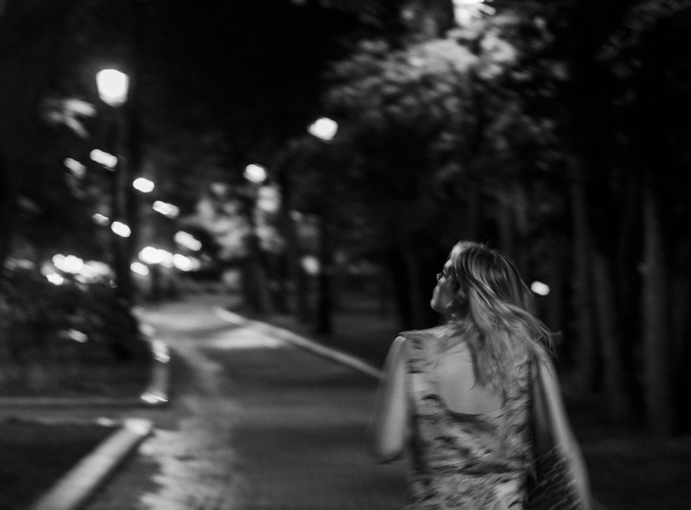 a woman walking down a street at night