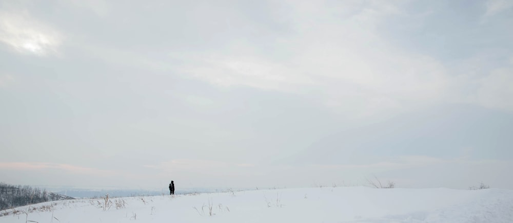 a person standing on a snow covered hill