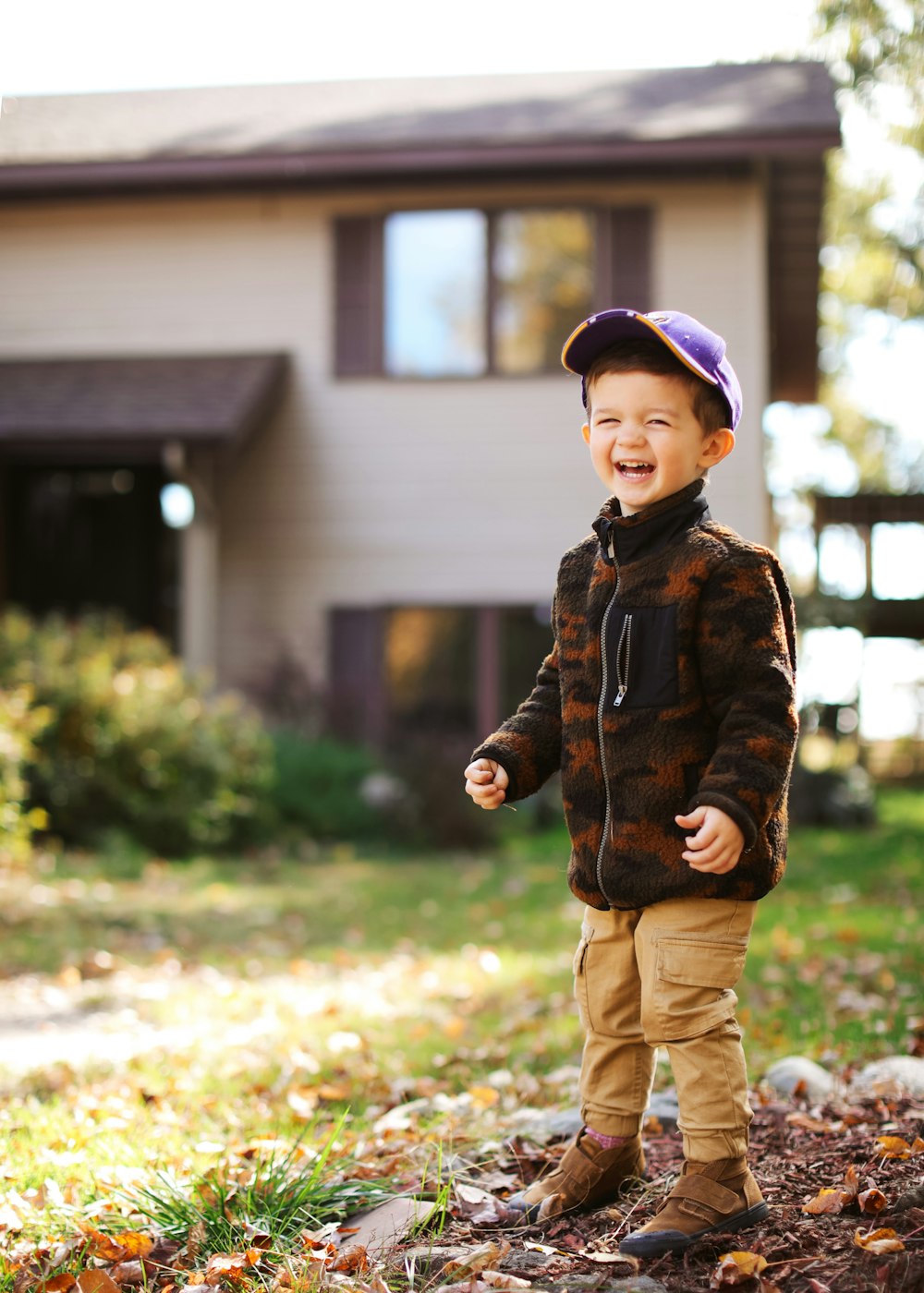 a young boy standing in front of a house