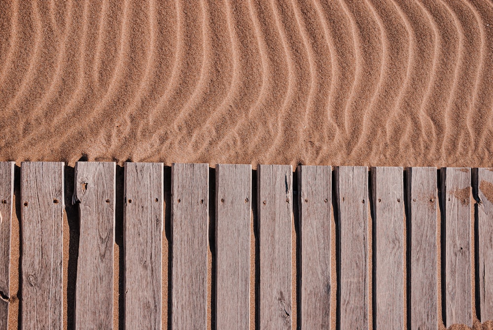 a wooden fence is in the sand