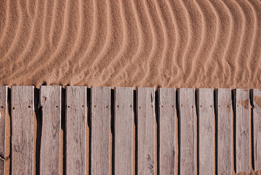 Una valla de madera está en la arena