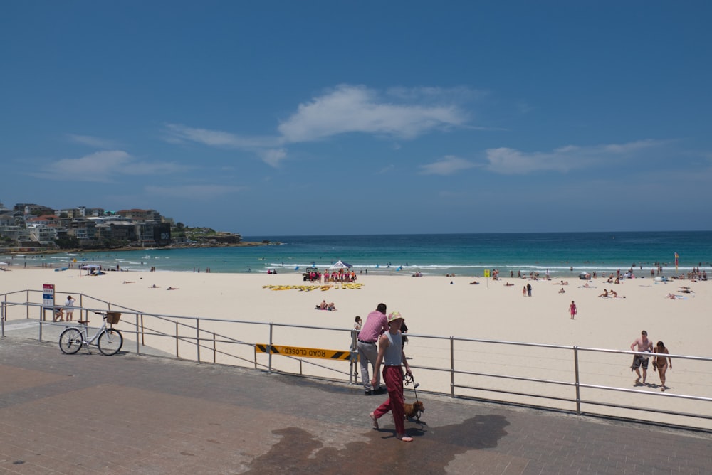 a group of people standing on top of a sandy beach