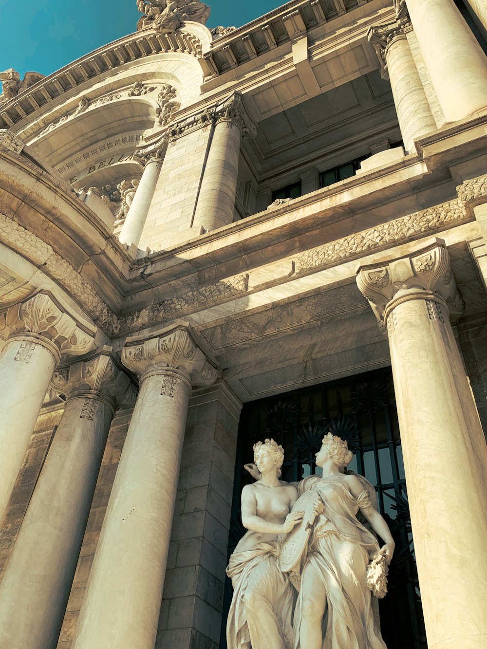 a statue of two women in front of a building