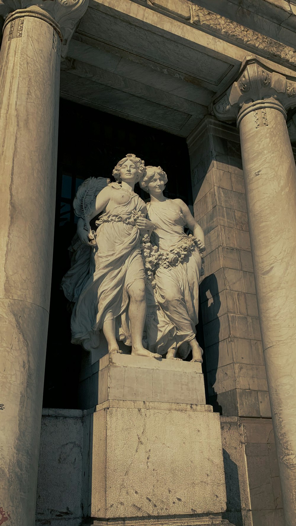 une statue de deux femmes debout l’une à côté de l’autre