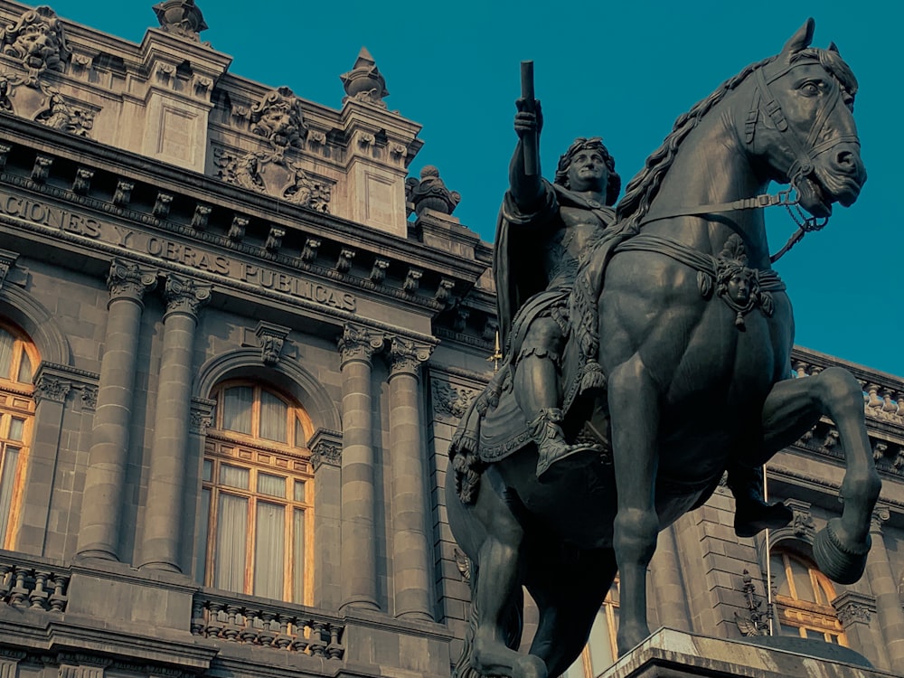 a statue of a man on a horse in front of a building