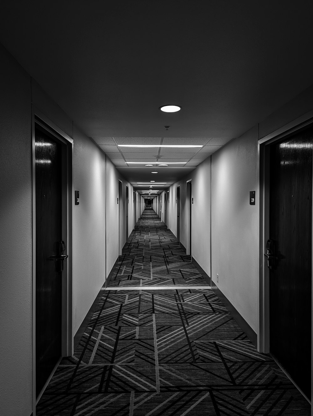 a long hallway with two doors leading to another room