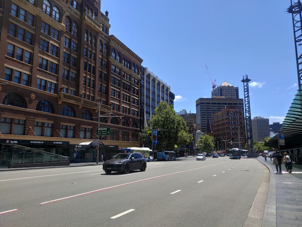 a car driving down a street next to tall buildings