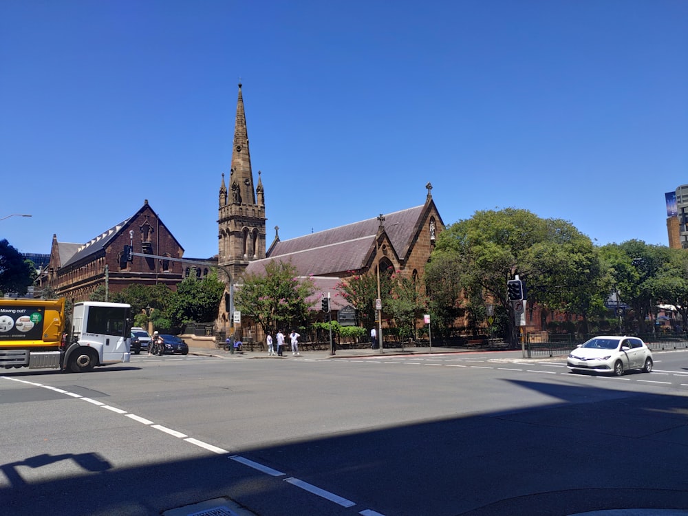 a truck driving down a street next to a church