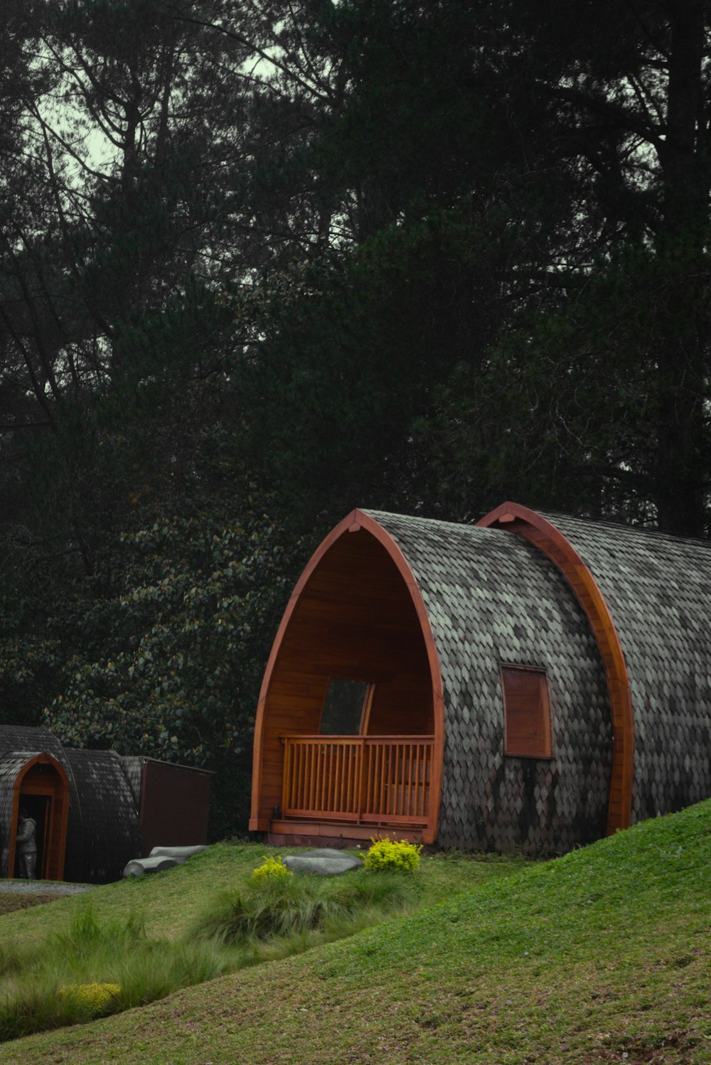 a couple of wooden buildings sitting on top of a lush green hillside