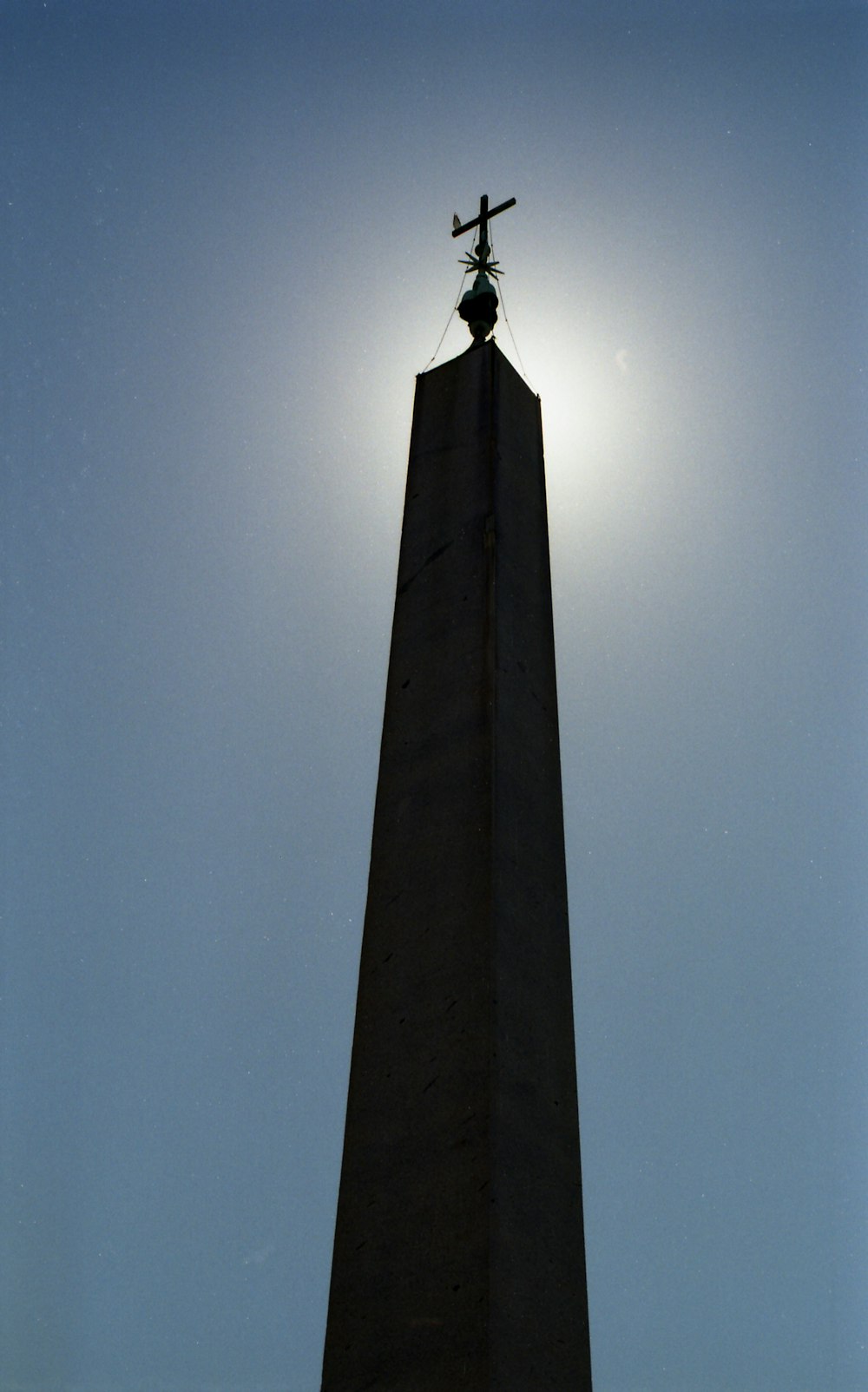 la parte superior de un monumento alto con una cruz en él