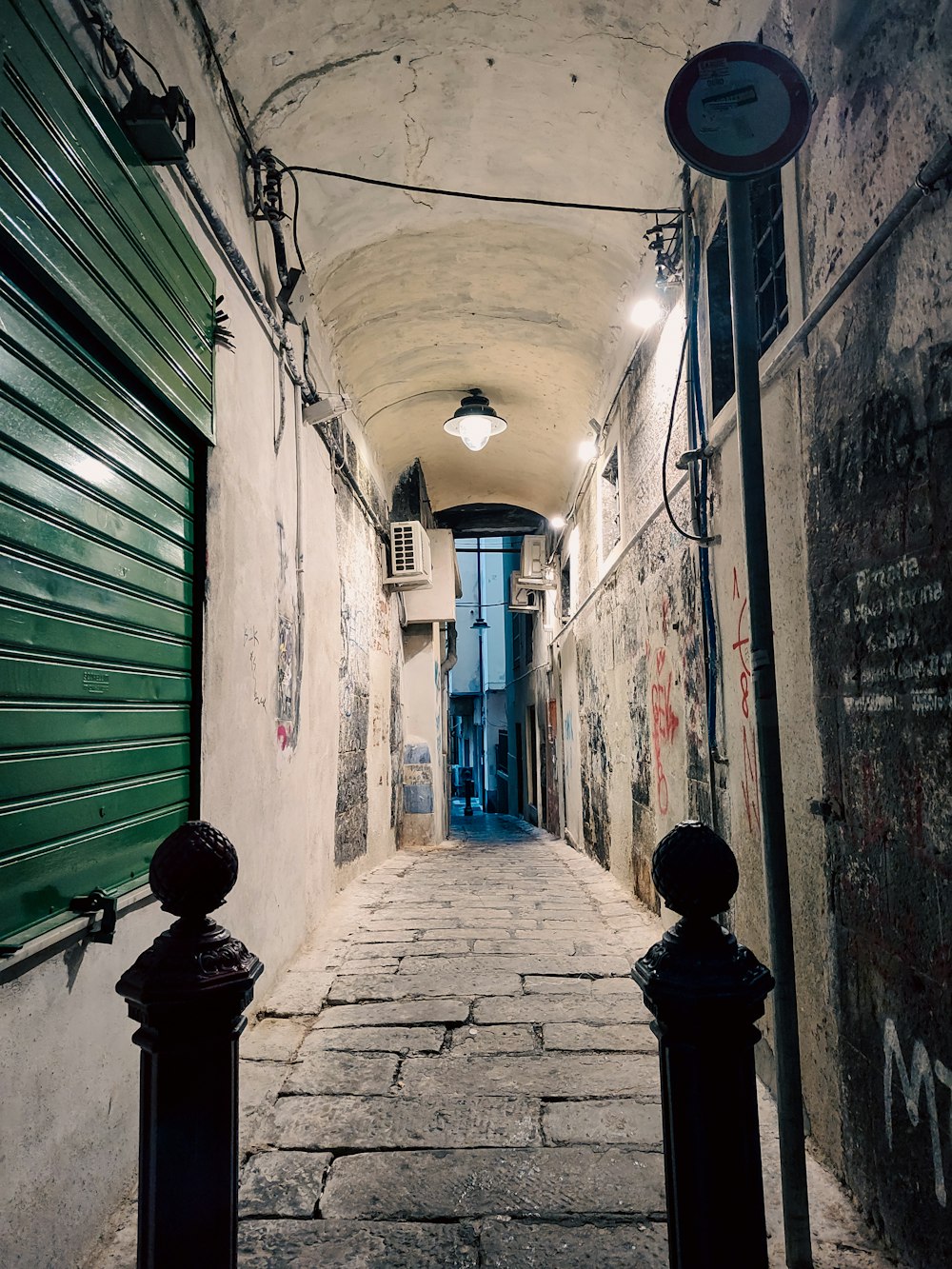 a narrow alley way with graffiti on the walls