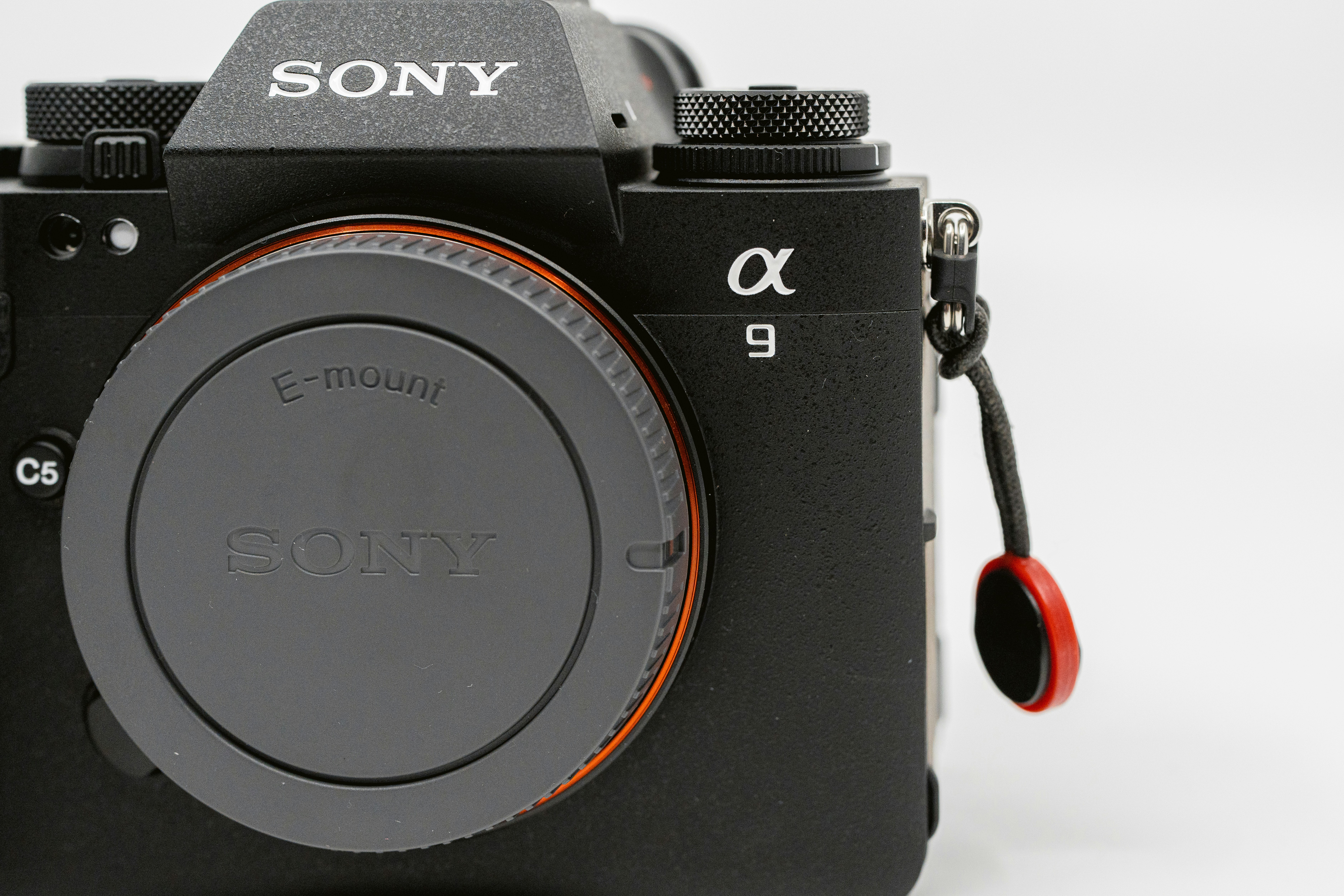 a black sony camera with a red lens