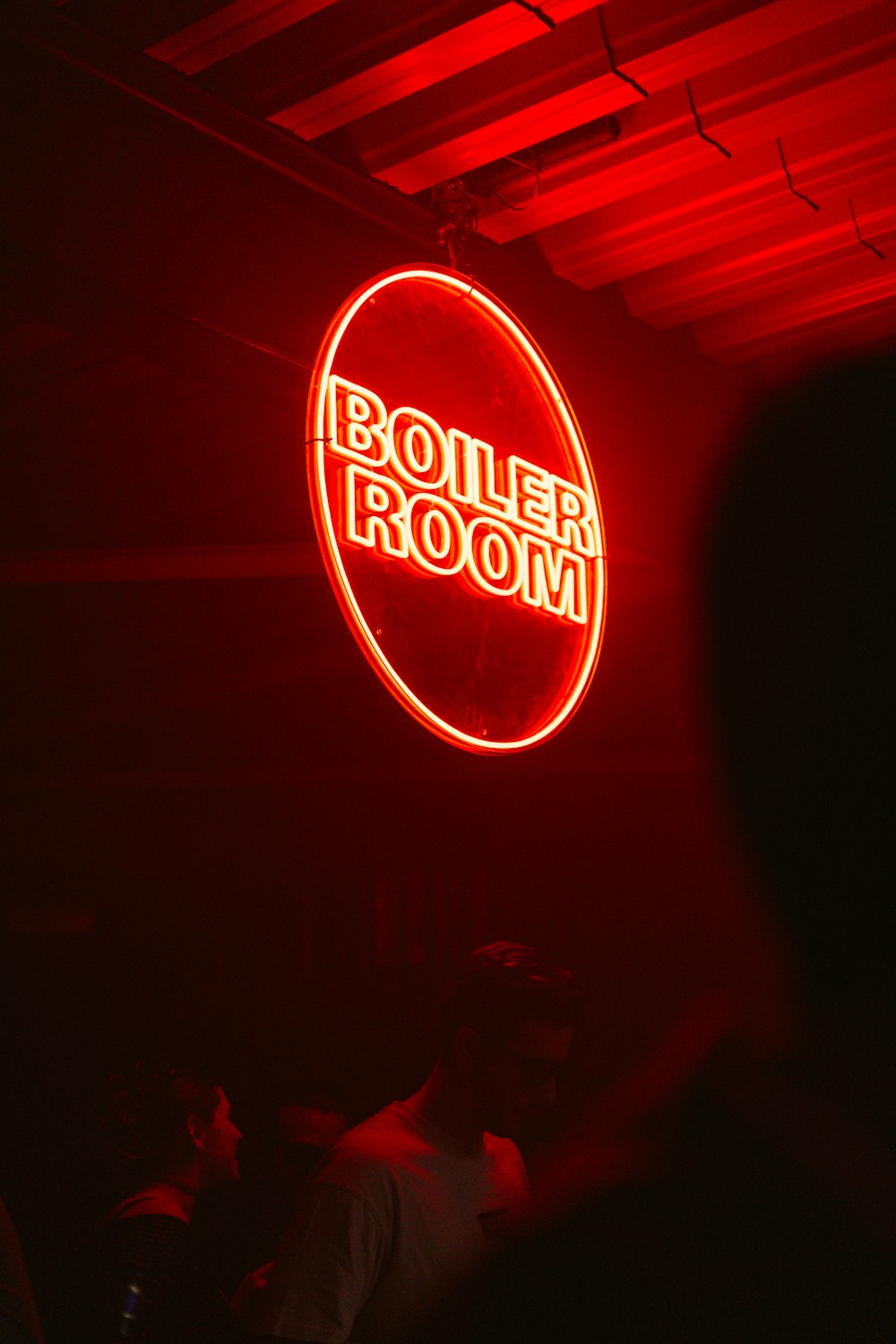 a red neon sign hanging from the ceiling of a room