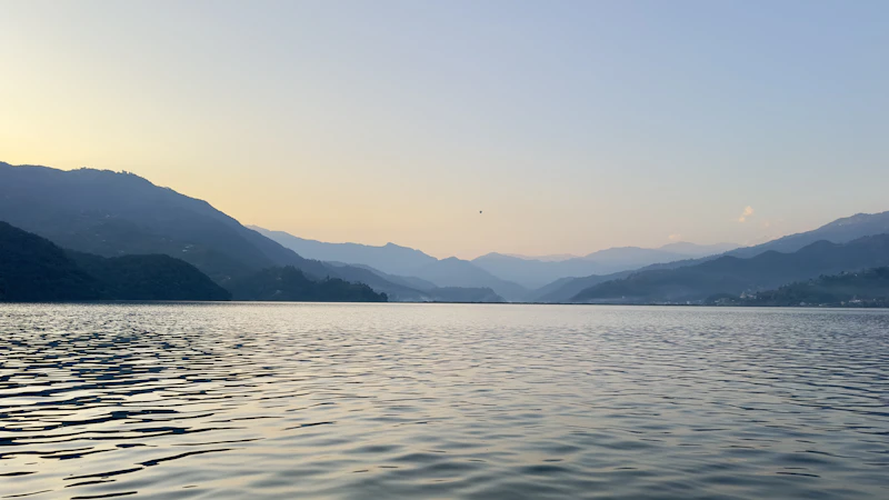 Atardecer sobre el lago Phewa con montañas de fondo