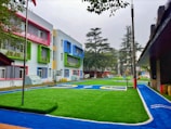 a row of multi - colored buildings with a playground in the foreground