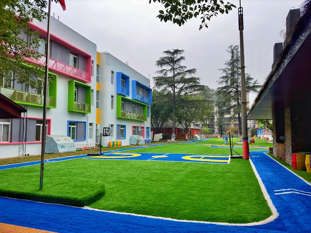 a row of multi - colored buildings with a playground in the foreground