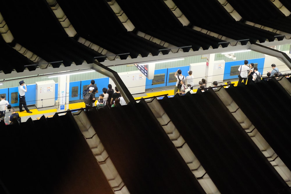 a group of people standing on a platform next to a train