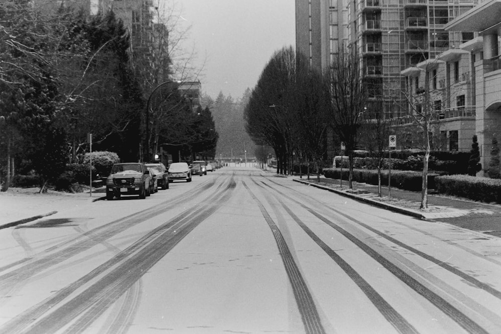 a black and white photo of a snow covered street