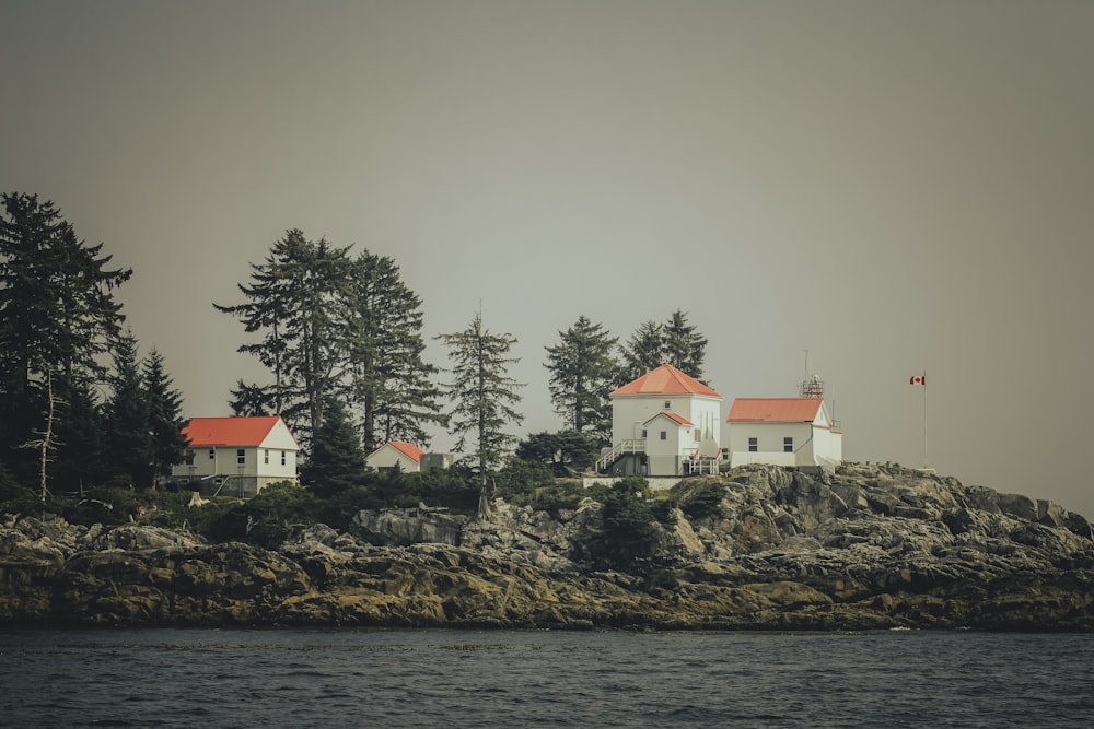 a lighthouse on a rocky island with trees in the background