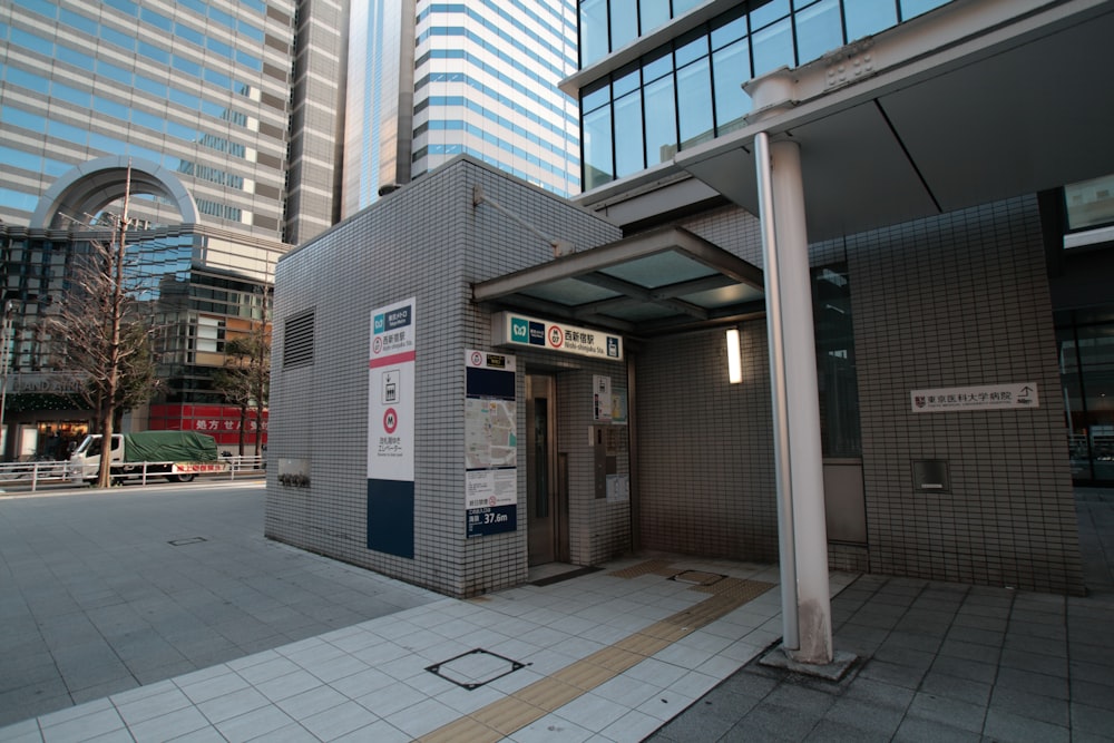 a public restroom in a city with tall buildings in the background