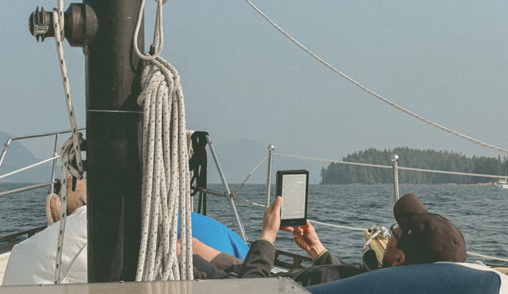 a person sitting on a boat using a cell phone