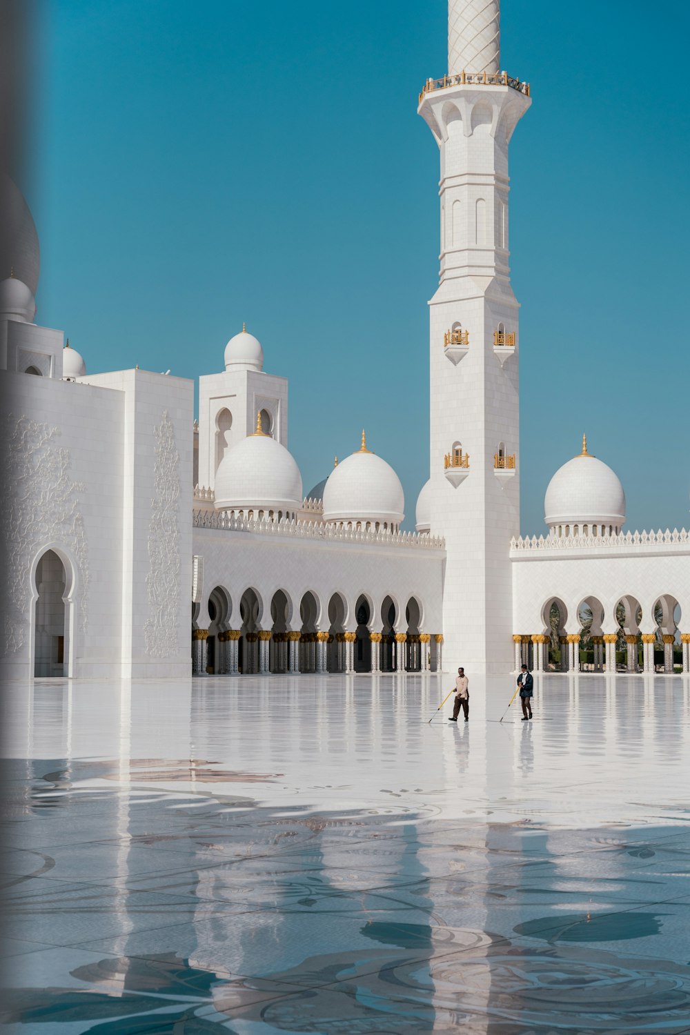 two people standing in front of a white building