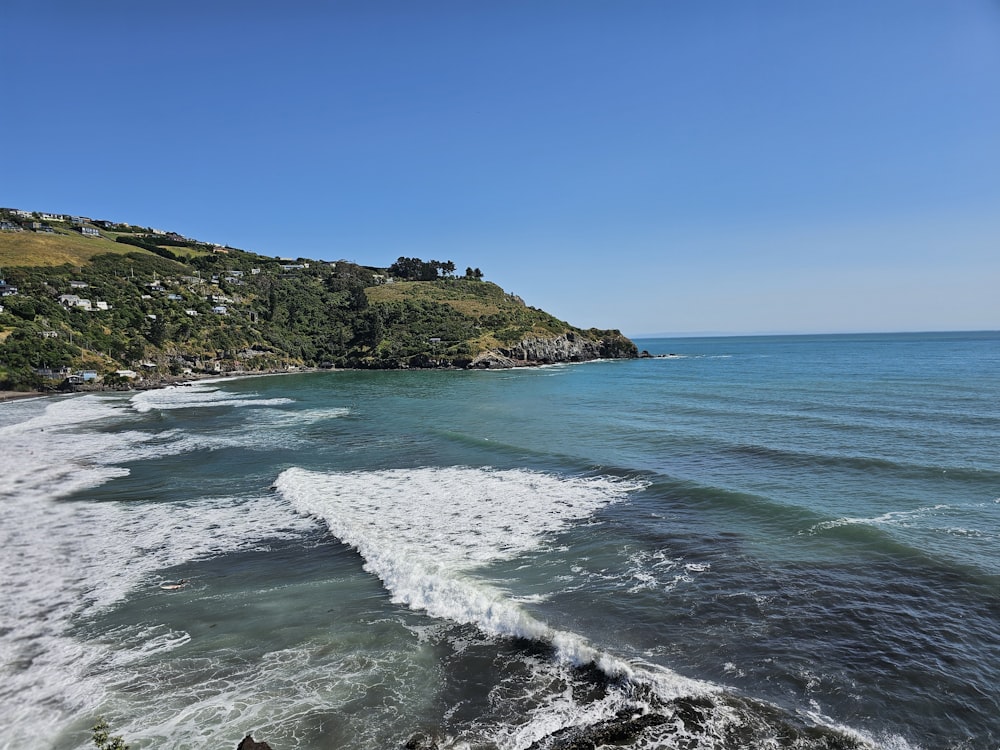 a body of water with a hill in the background