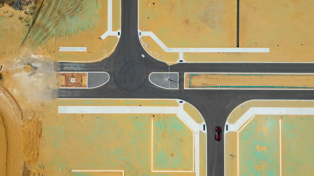 an aerial view of an intersection with a red car
