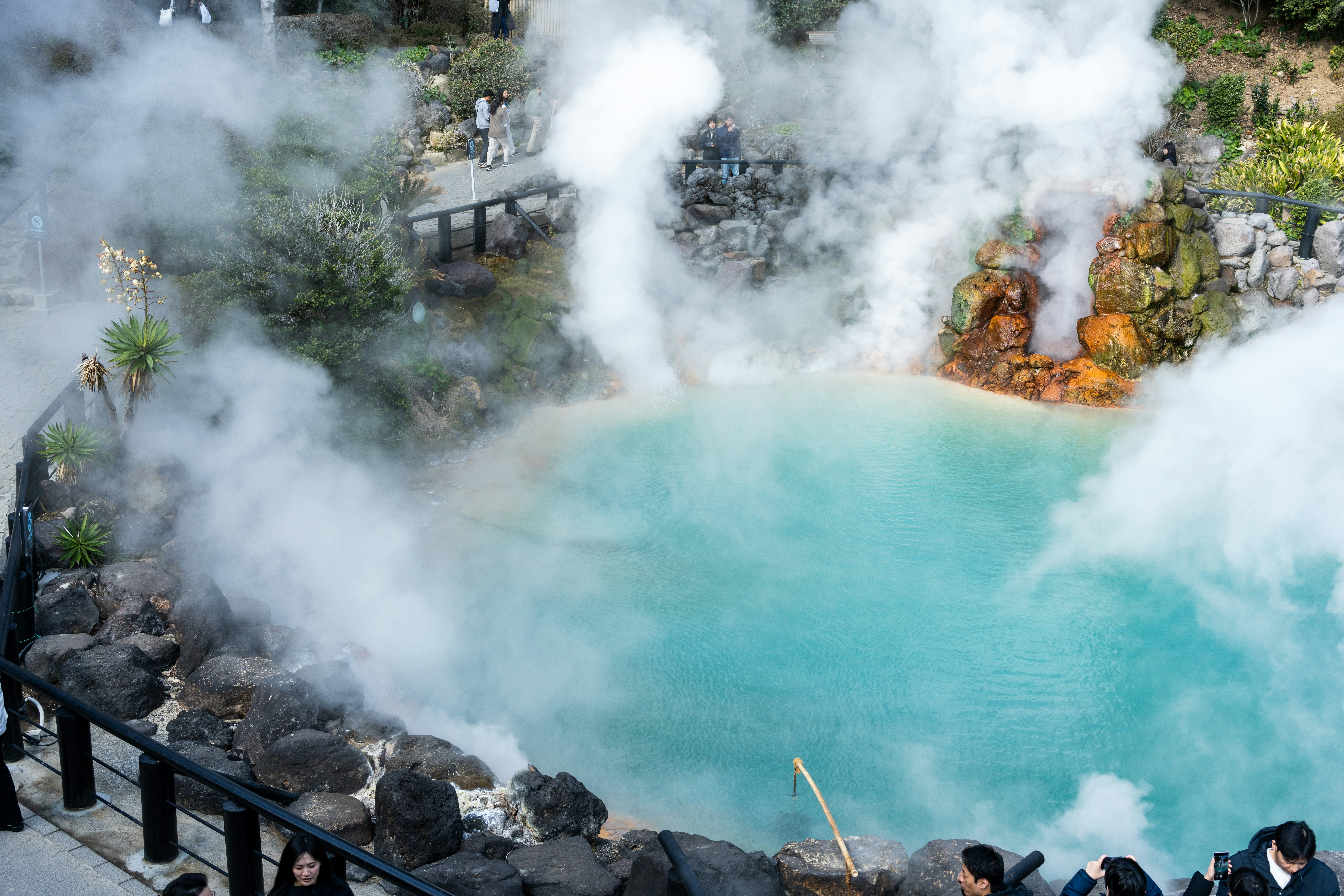 a group of people standing around a pool of water