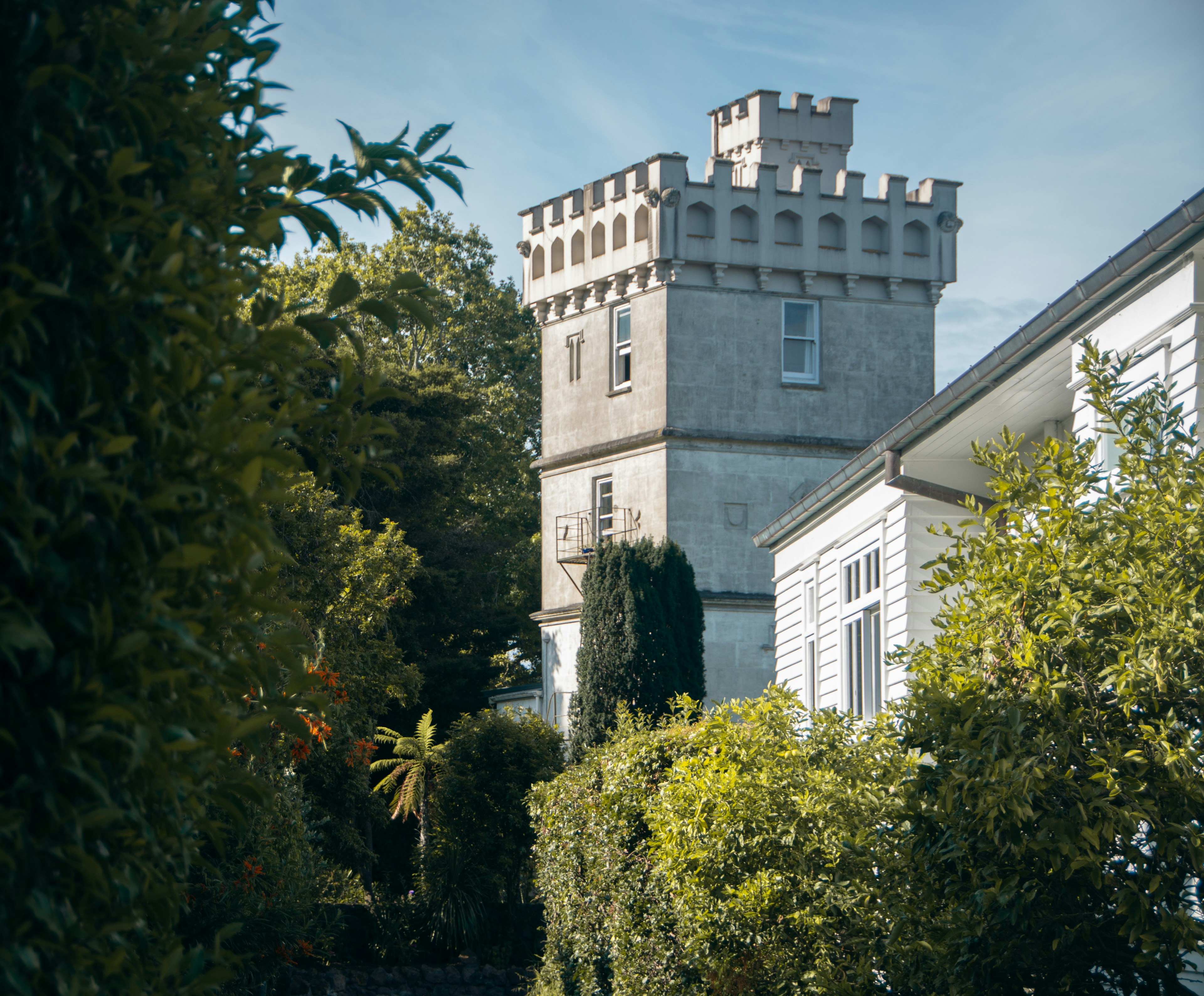 a castle like building surrounded by trees and bushes, A castle as part of a house