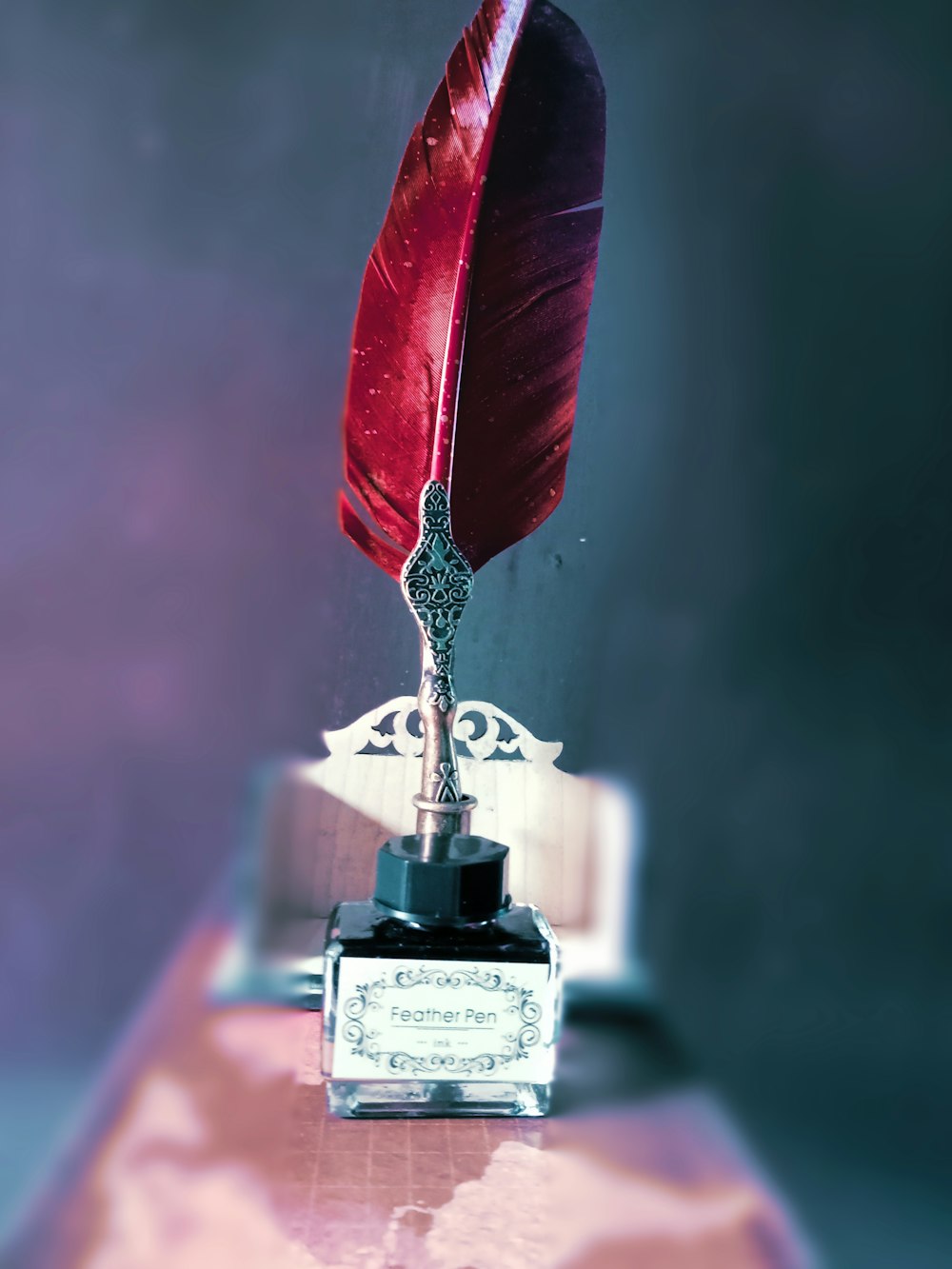 a red feather quill sitting on top of a desk