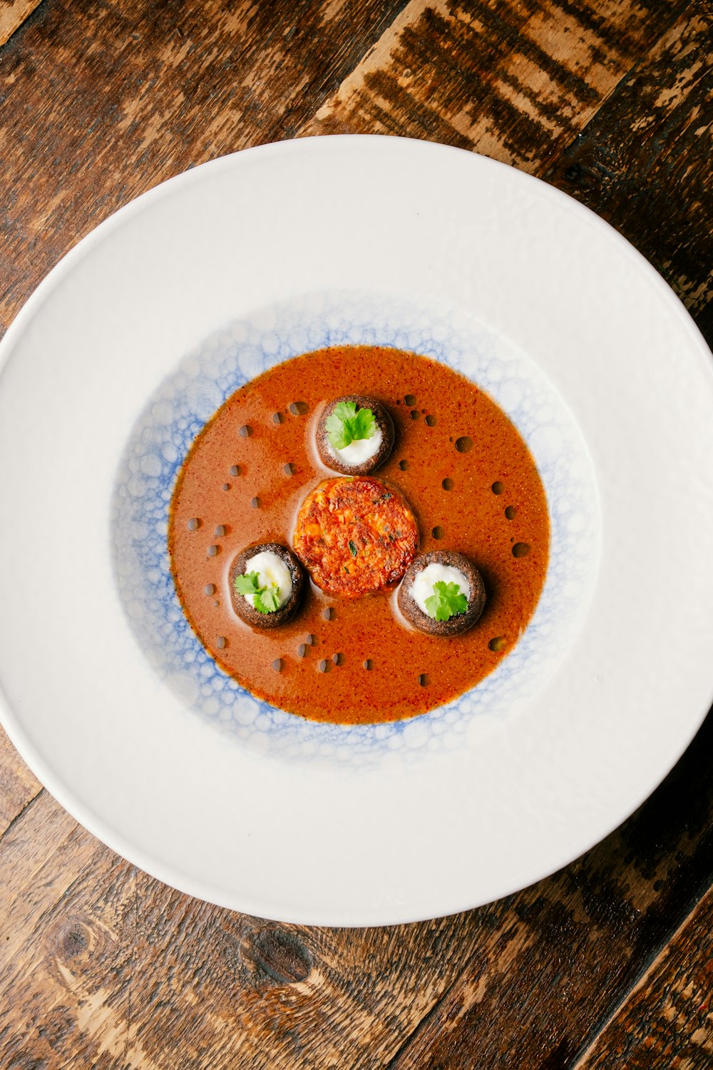 a white plate topped with a soup covered in broccoli