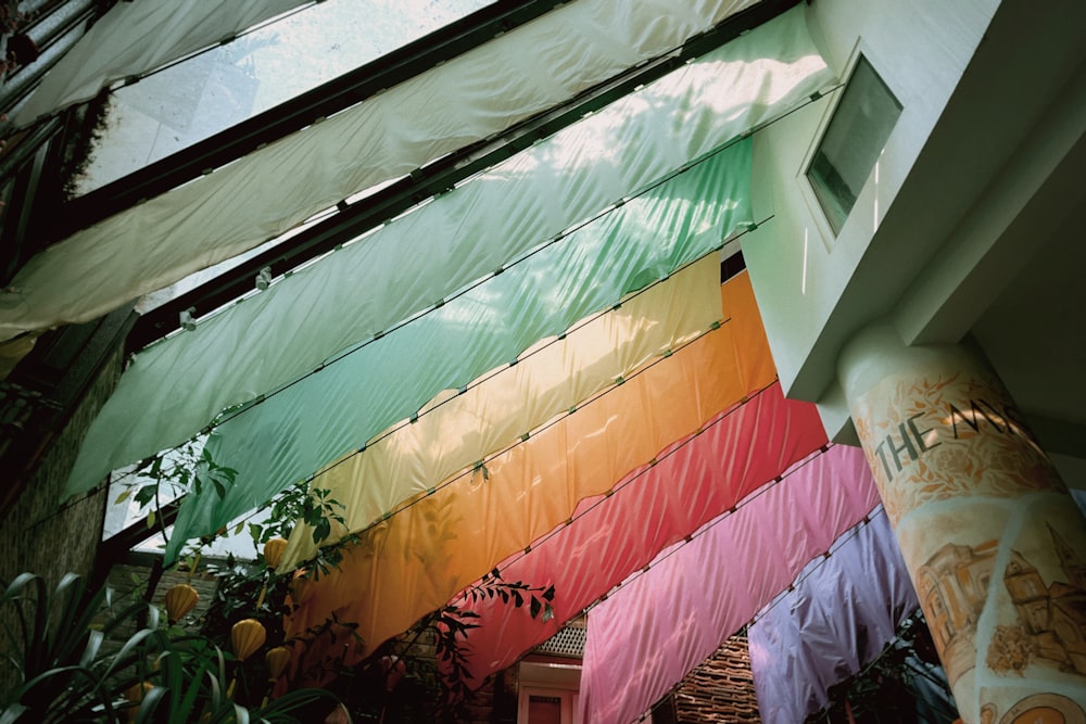 a building with a bunch of colorful flags hanging from it's side