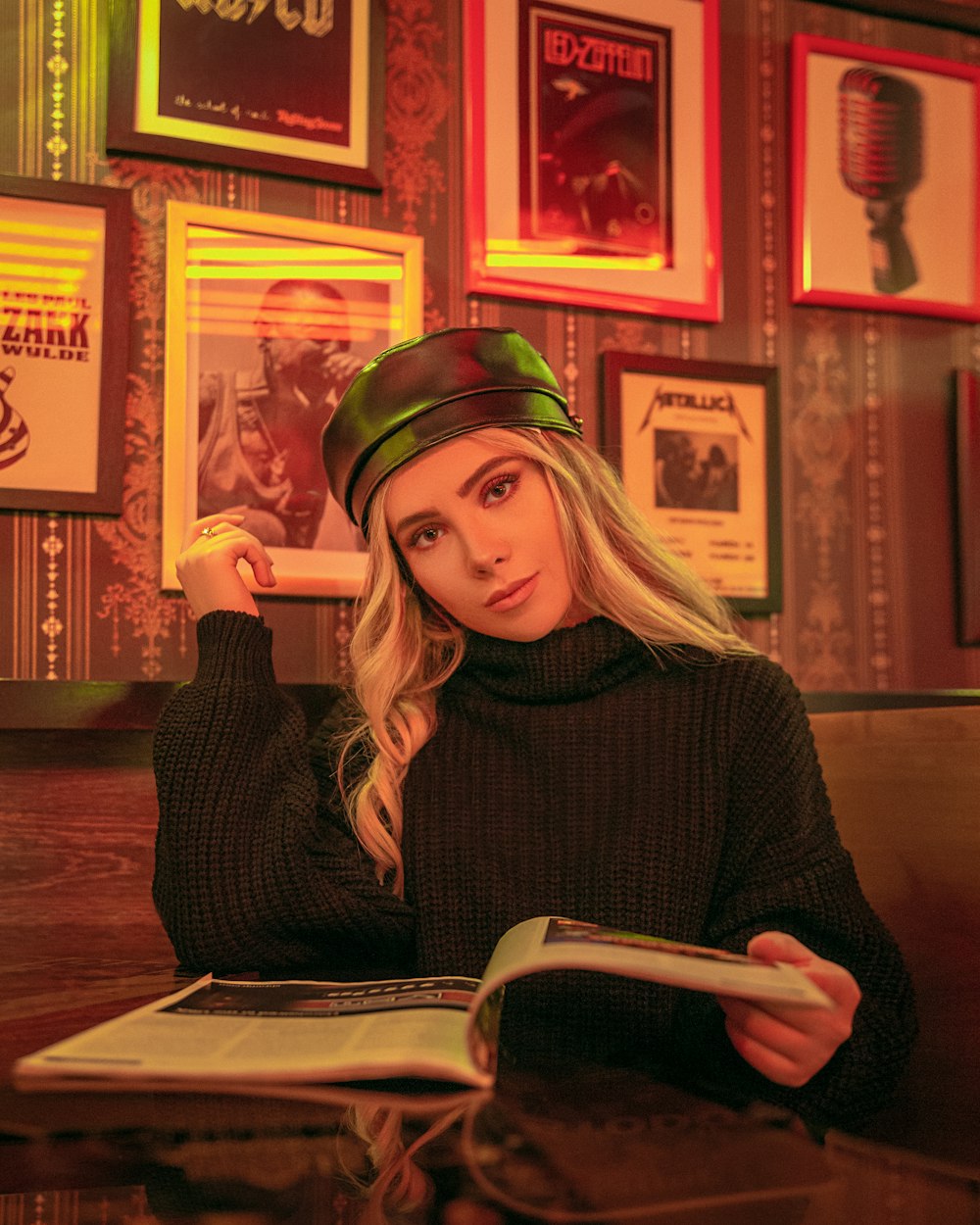 a woman sitting at a table reading a book