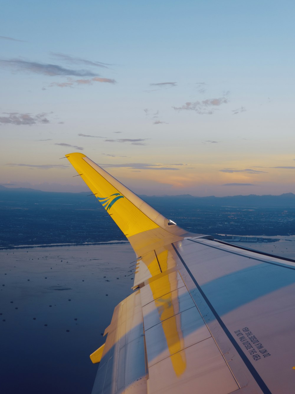 the wing of an airplane flying over a body of water