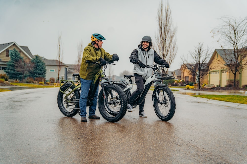 a couple of men standing next to each other on motorcycles