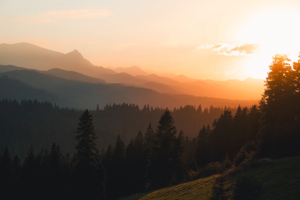 the sun is setting over a mountain range